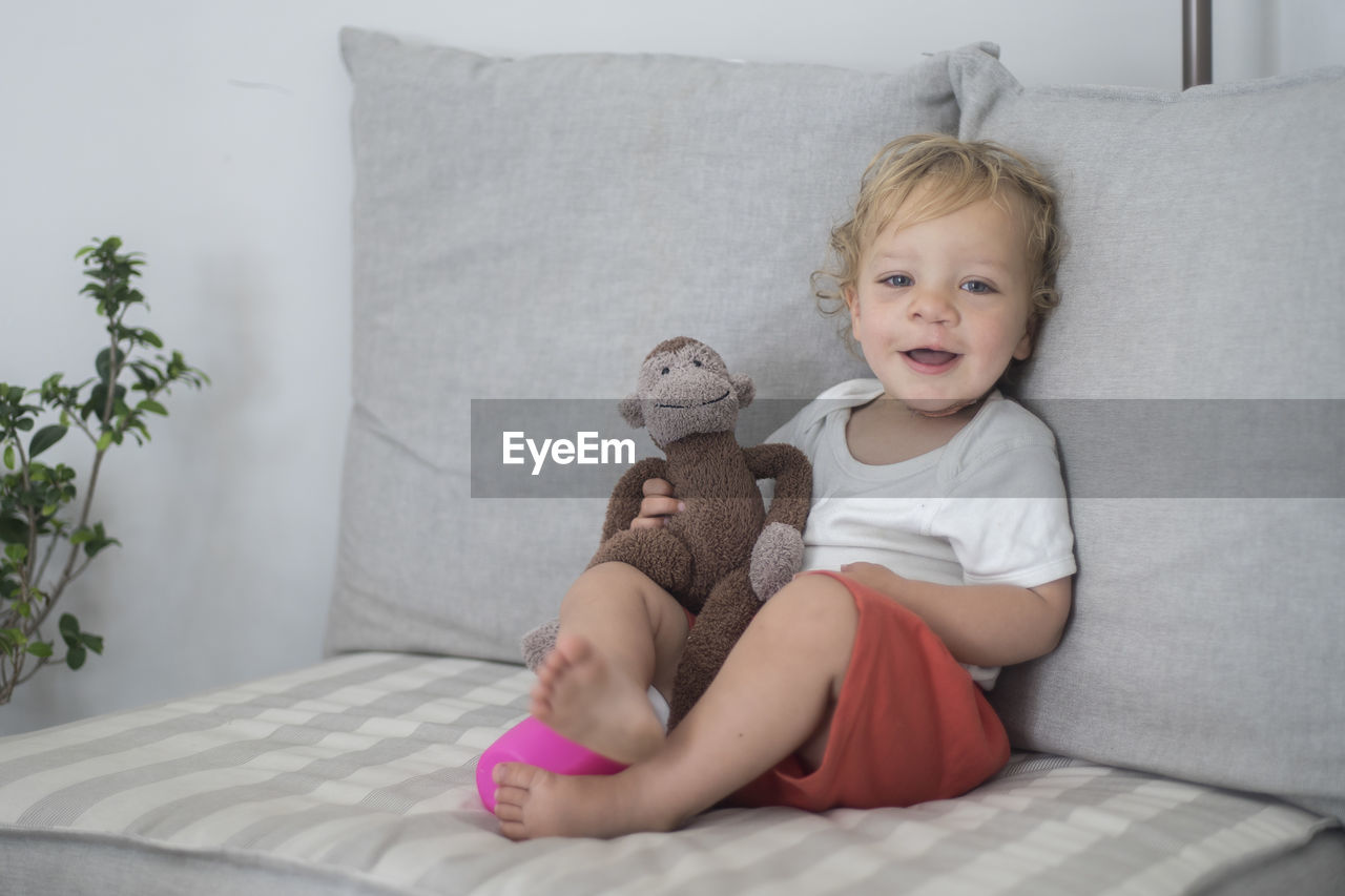 Portrait of smiling girl sitting on sofa