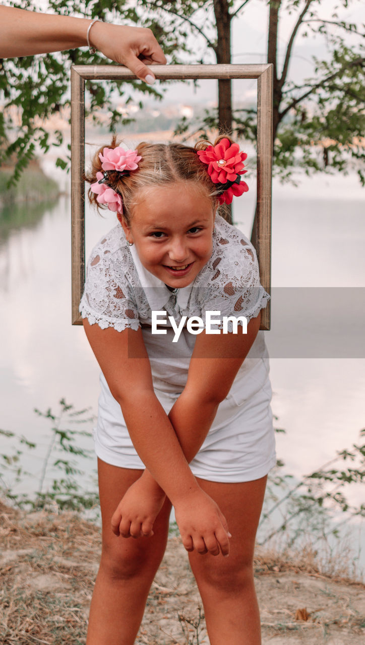 Portrait of girl standing against plants