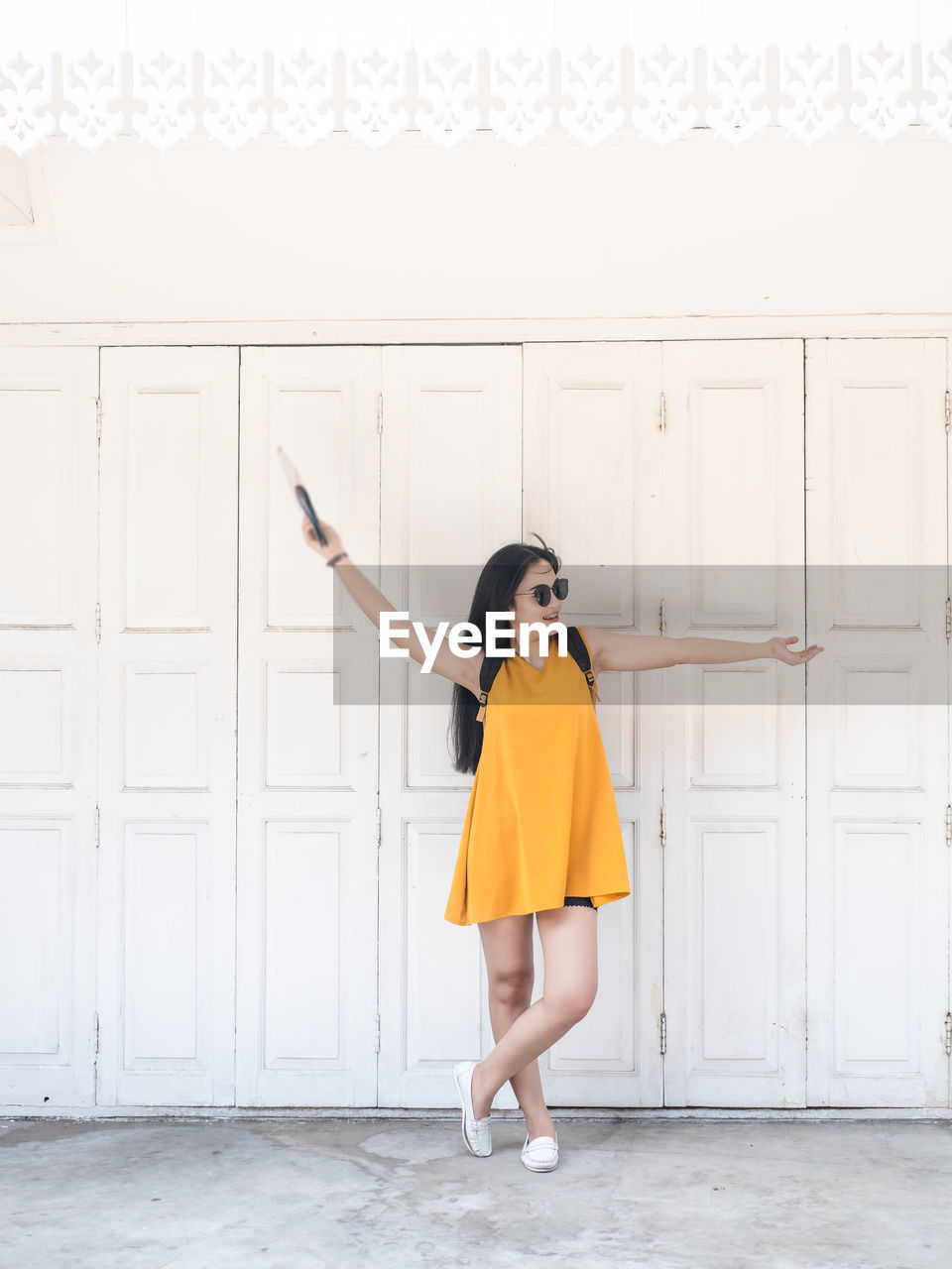 Portrait of woman standing against door