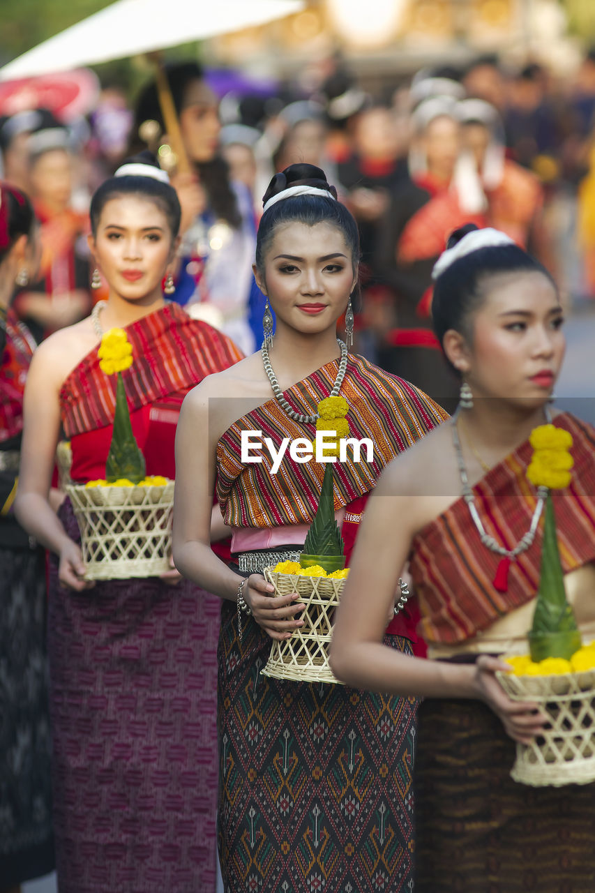 GROUP OF PEOPLE IN TRADITIONAL CLOTHING STANDING OUTDOORS