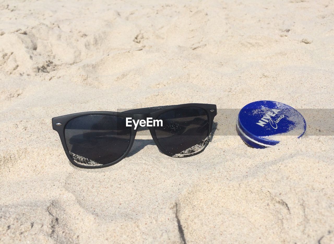 HIGH ANGLE VIEW OF SUNGLASSES ON THE BEACH