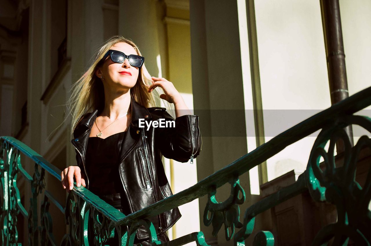 Portrait of young woman wearing sunglasses standing outdoors