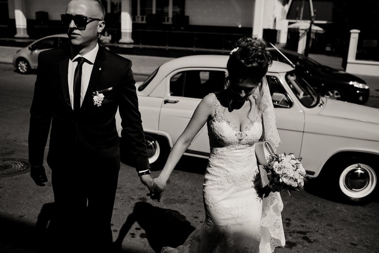 Bride and bridegroom walking on city street