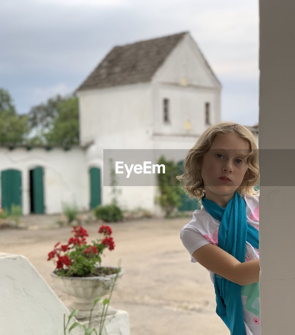 Portrait of cute girl standing against building