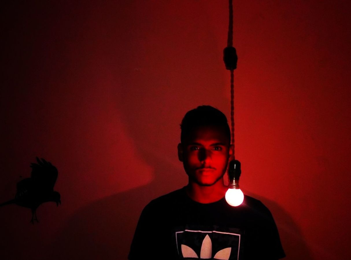 CLOSE-UP OF BOY AGAINST ILLUMINATED BACKGROUND