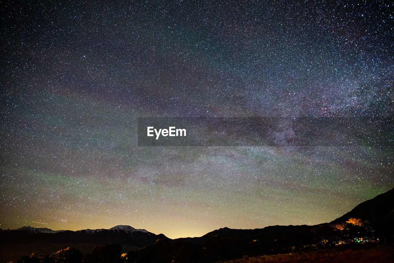 SCENIC VIEW OF SILHOUETTE MOUNTAINS AGAINST STAR FIELD