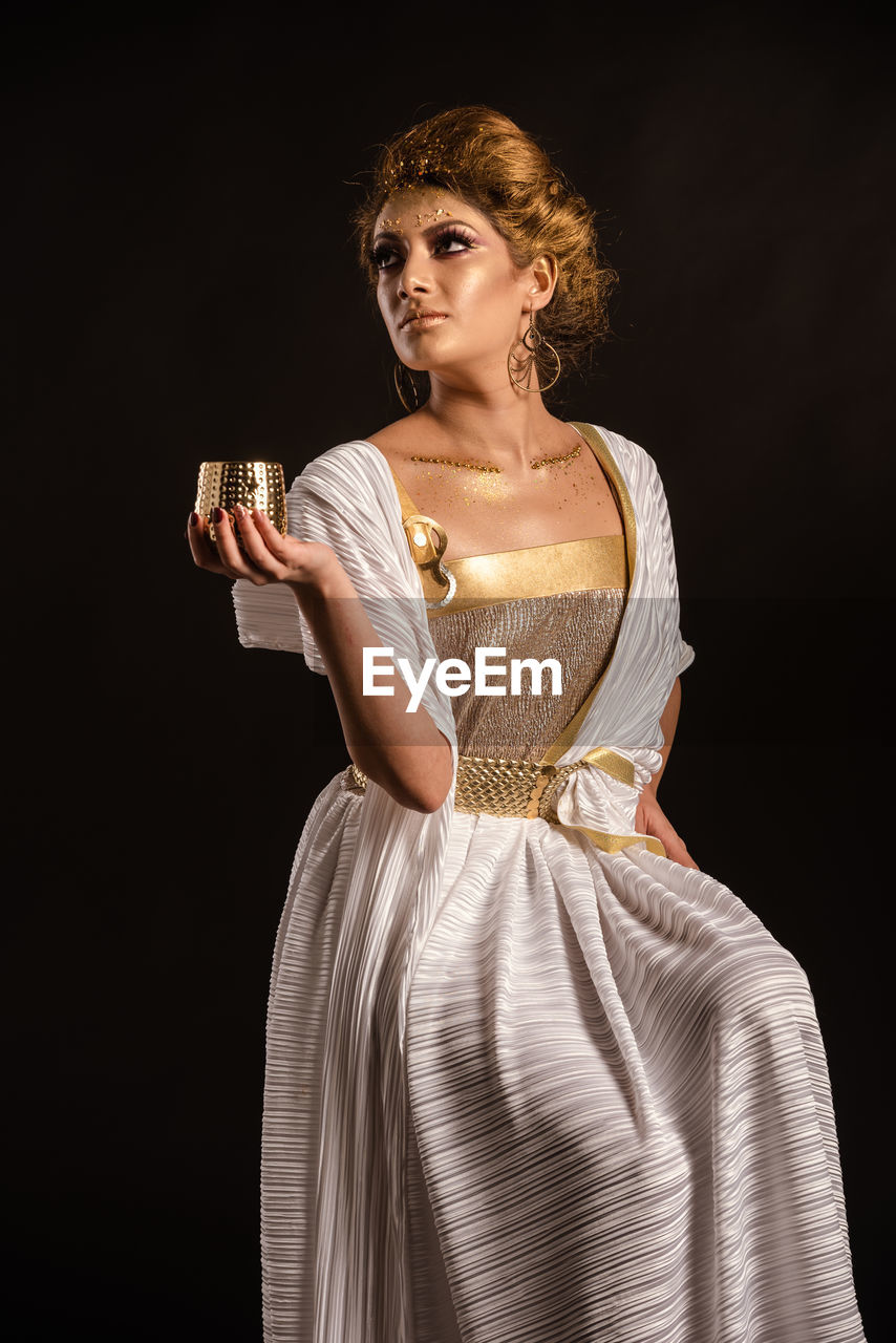 Portrait of a beautiful young woman over black background