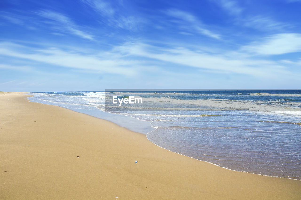 Scenic view of beach against cloudy sky