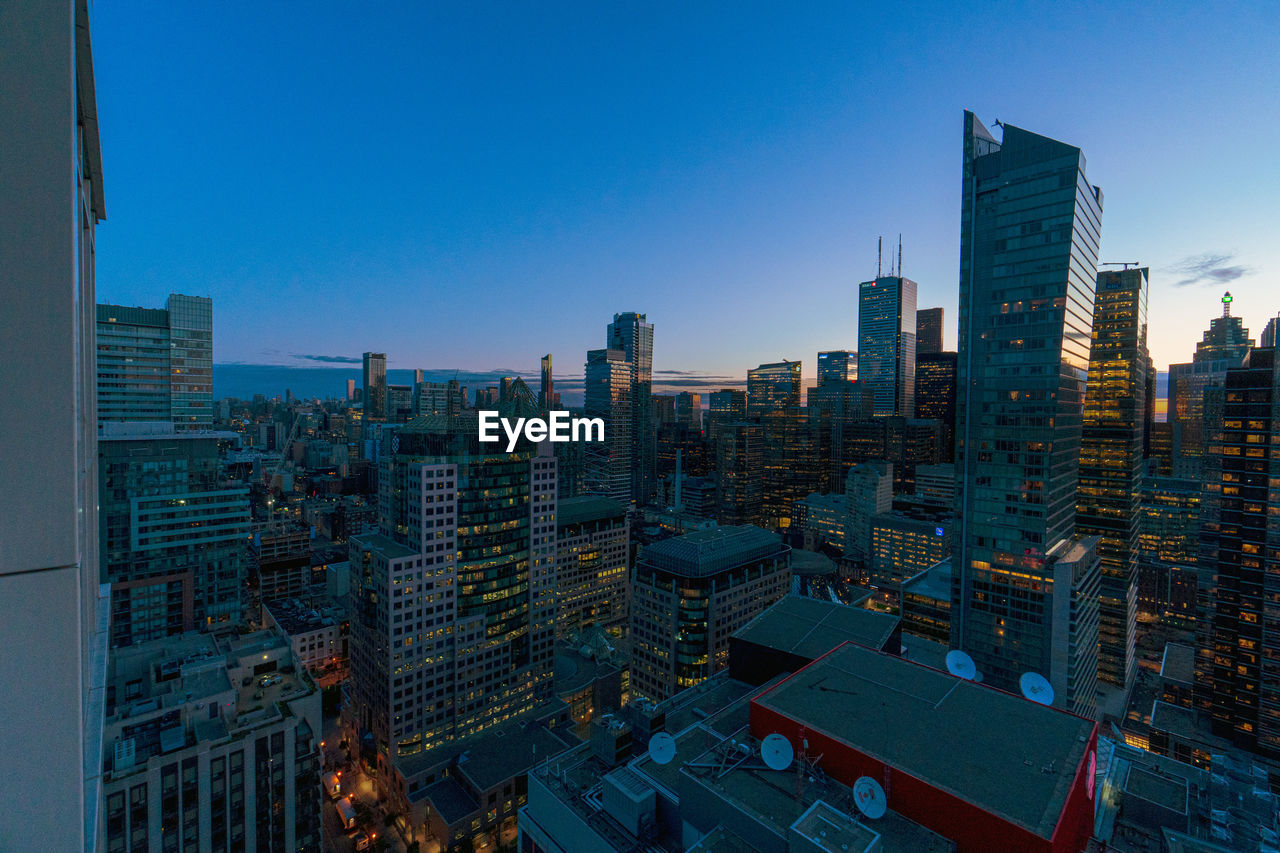 High angle view of buildings against clear blue sky