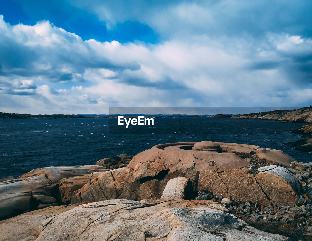 ROCKS ON SHORE AGAINST SKY