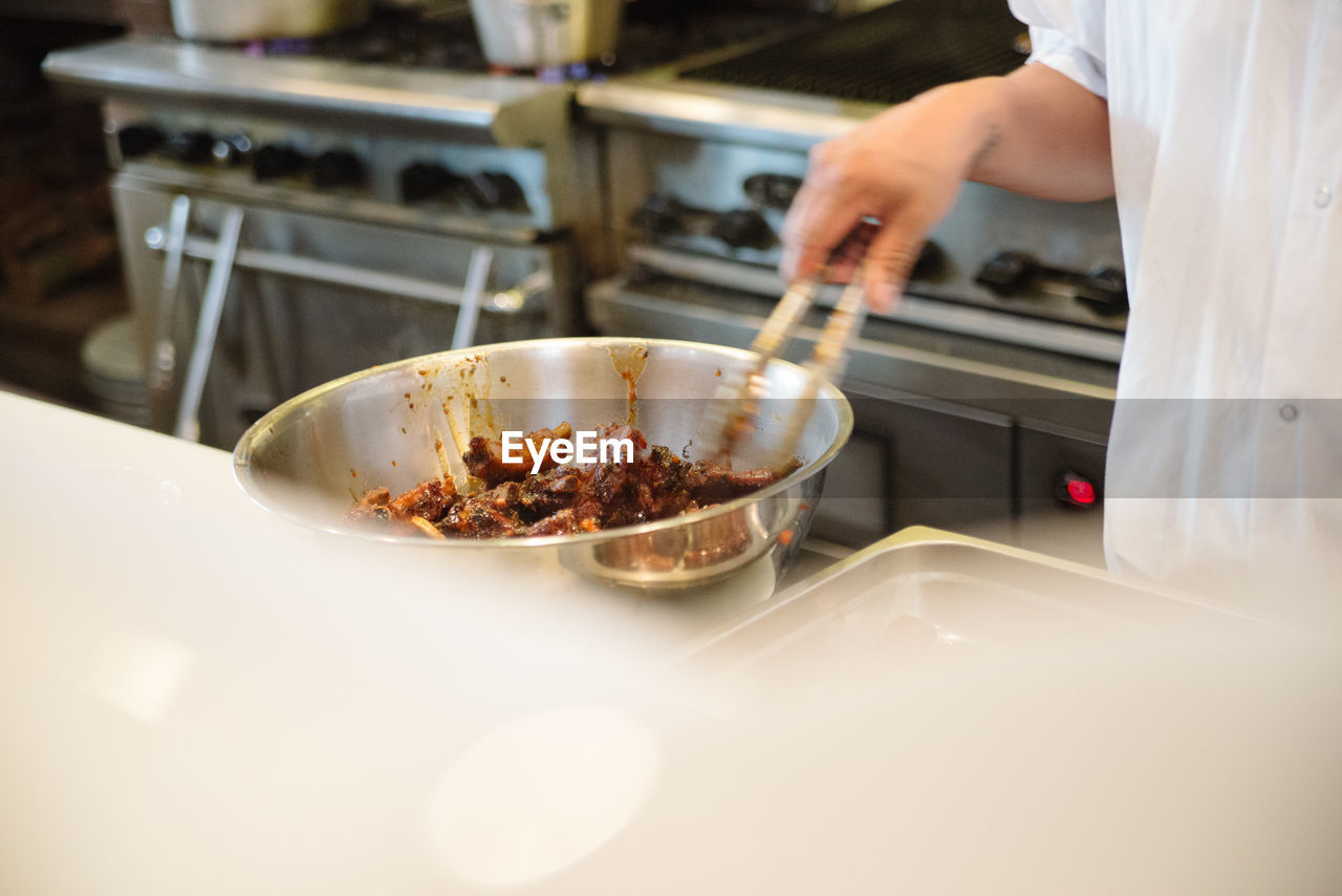 Midsection of chef preparing food in kitchen