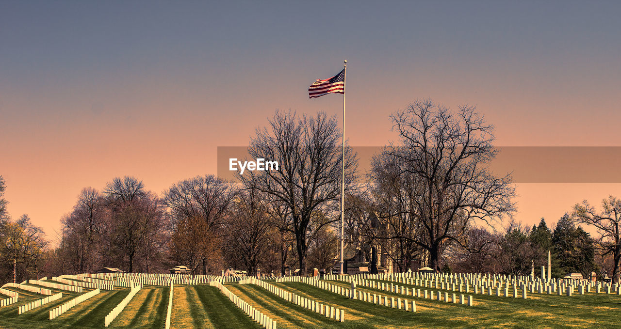 American flag at crown hill cemetery against sky during sunset