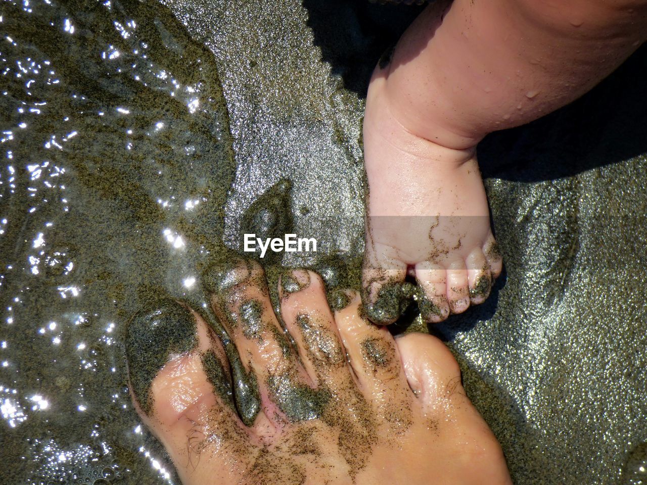 Father and baby feet on beach