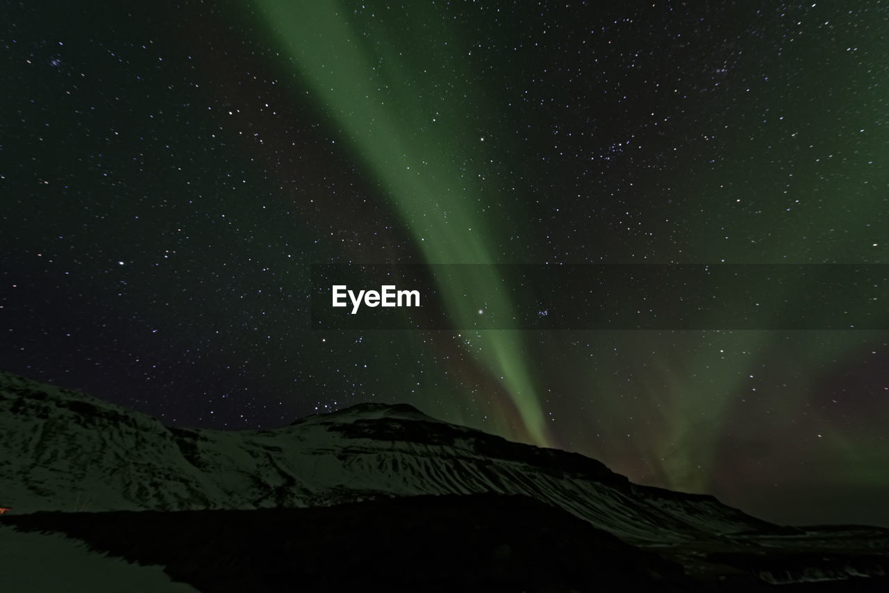 Low angle view of aurora borealis at night during winter