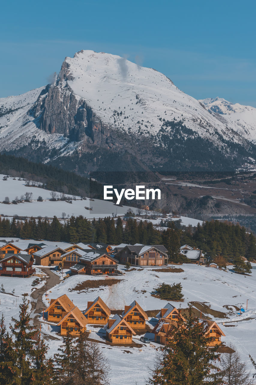 A picturesque vertical shot of the snowcapped french alps mountains and the ski resort buildings