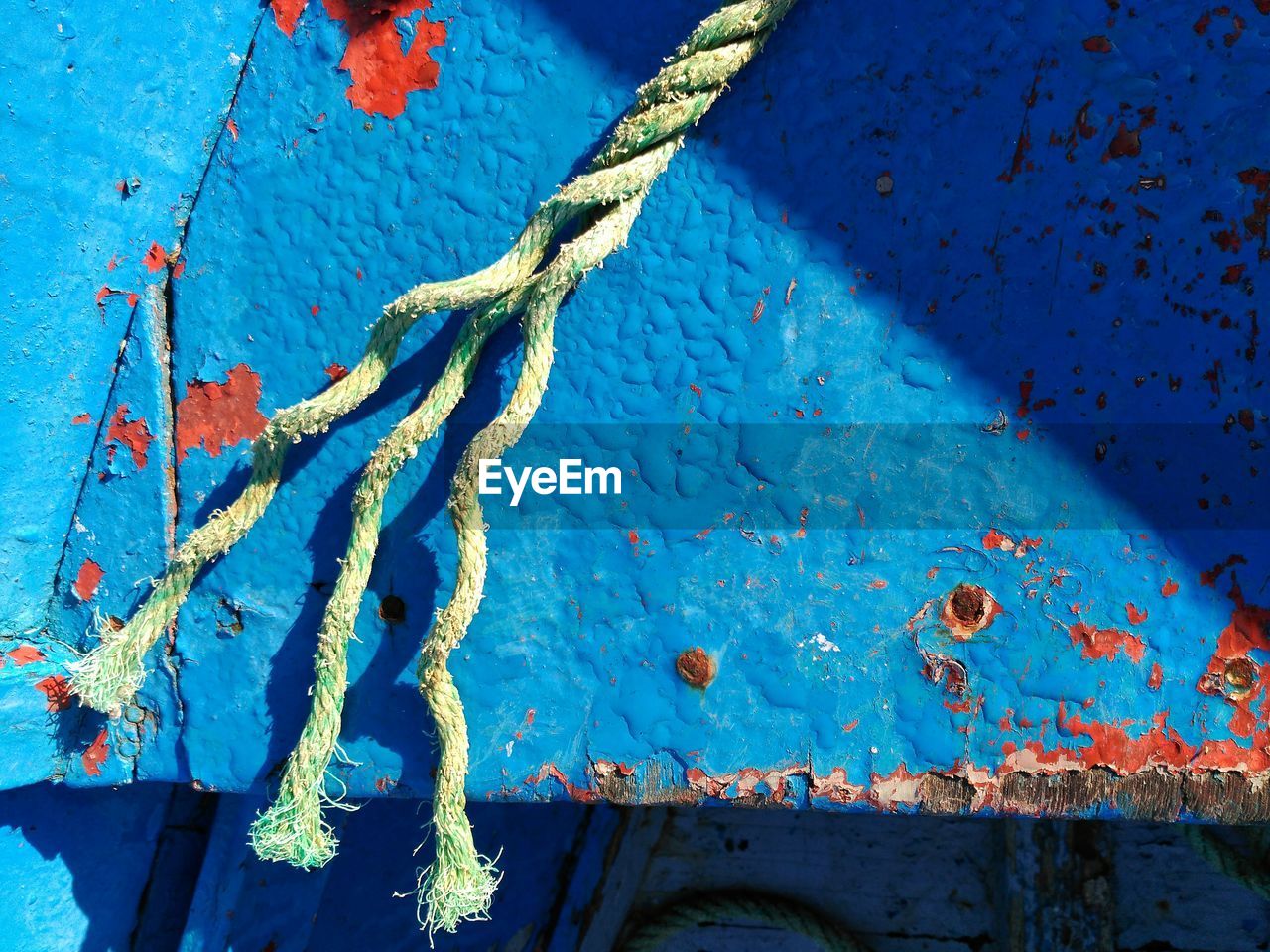 Close-up of rope against blue wall