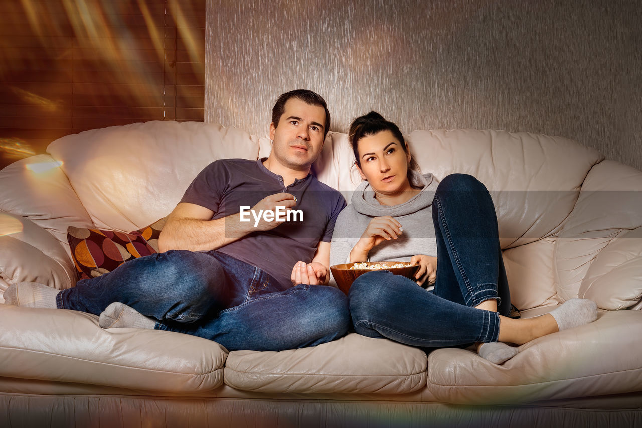 Young couple sitting on sofa home