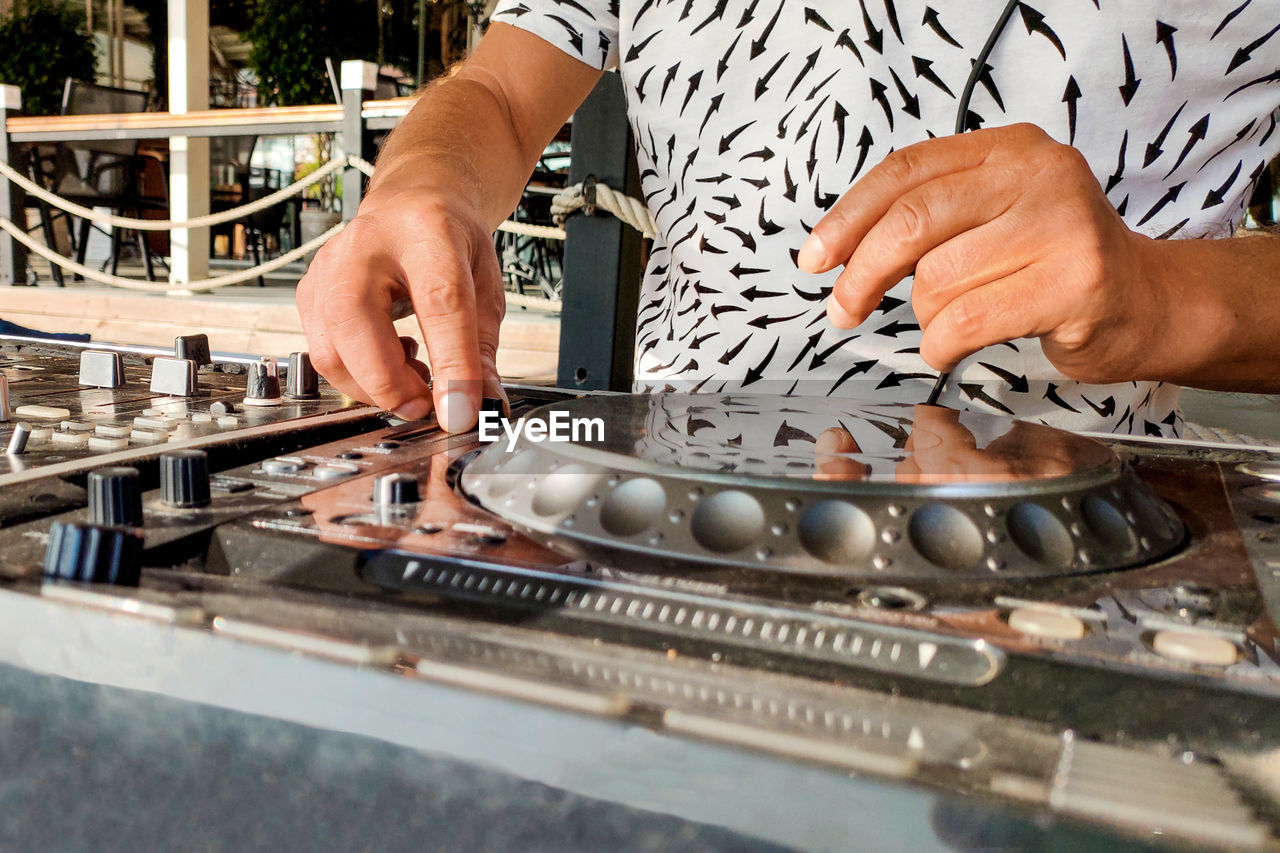 Turkey, alanya - august 12, 2022, dj's hands on mixing player close-up, on beach