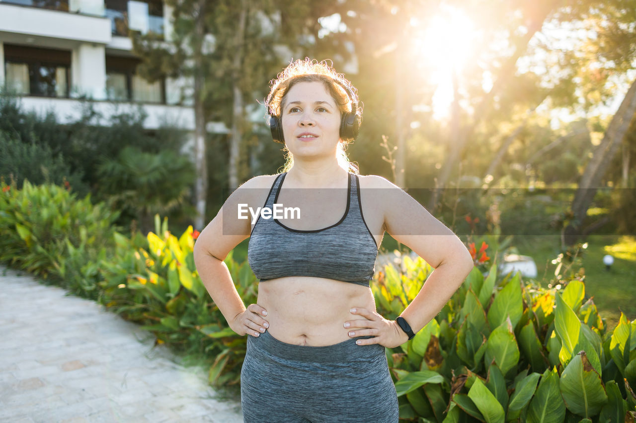 portrait of woman standing against plants