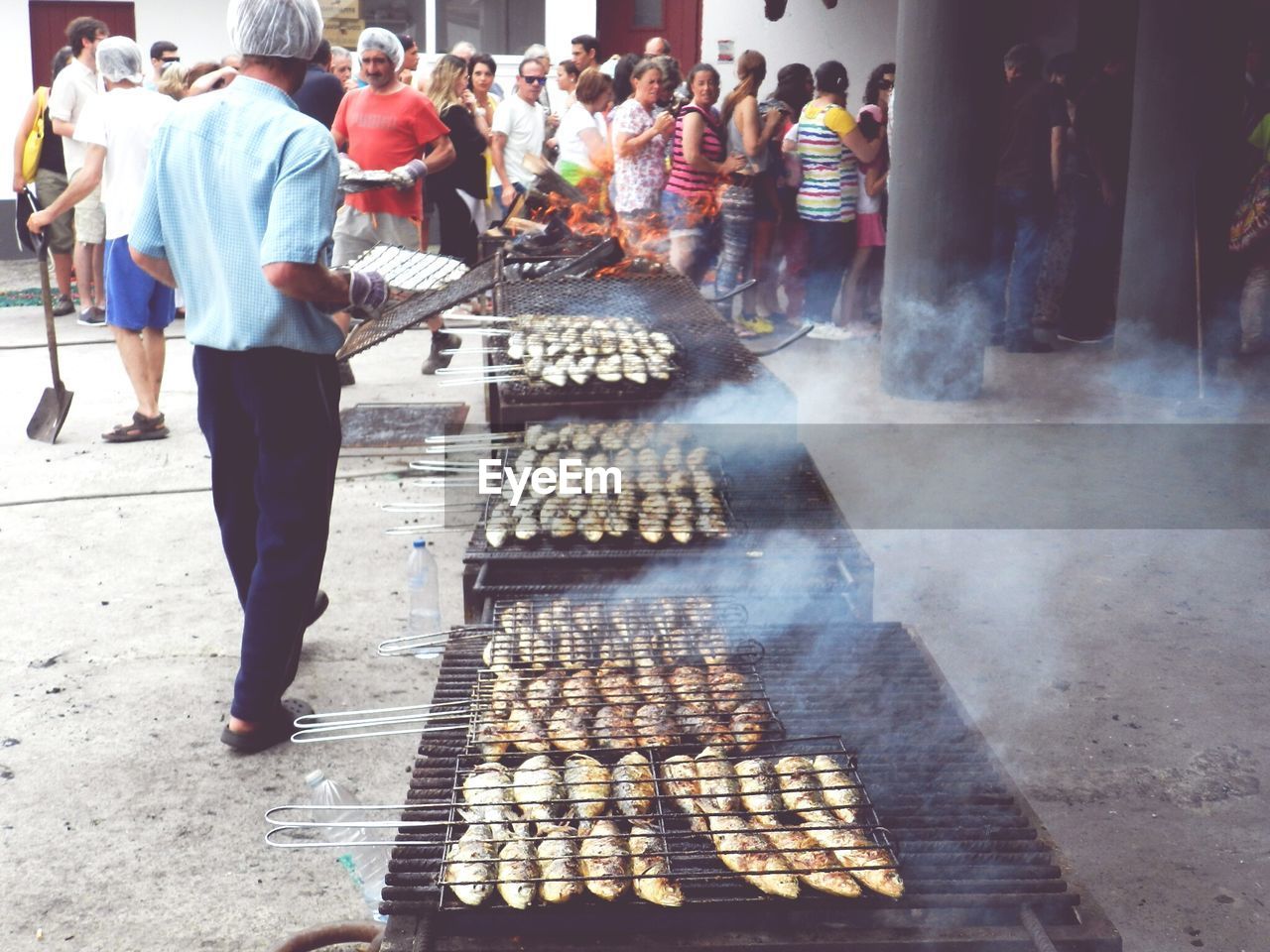 PEOPLE STANDING ON MARKET STALL