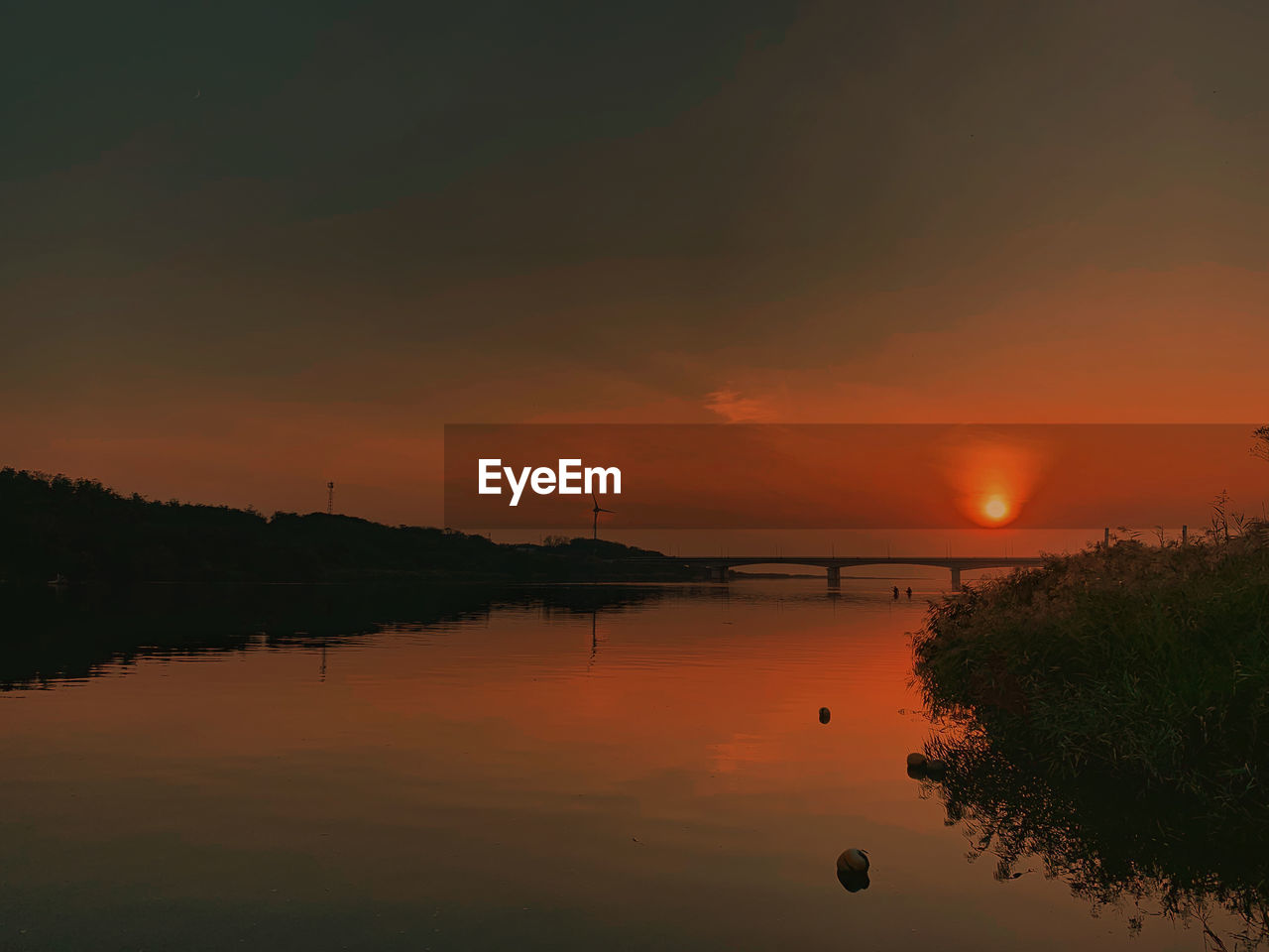 Scenic view of lake against orange sky