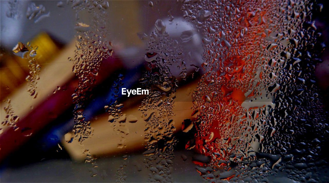 Books seen through wet glass window