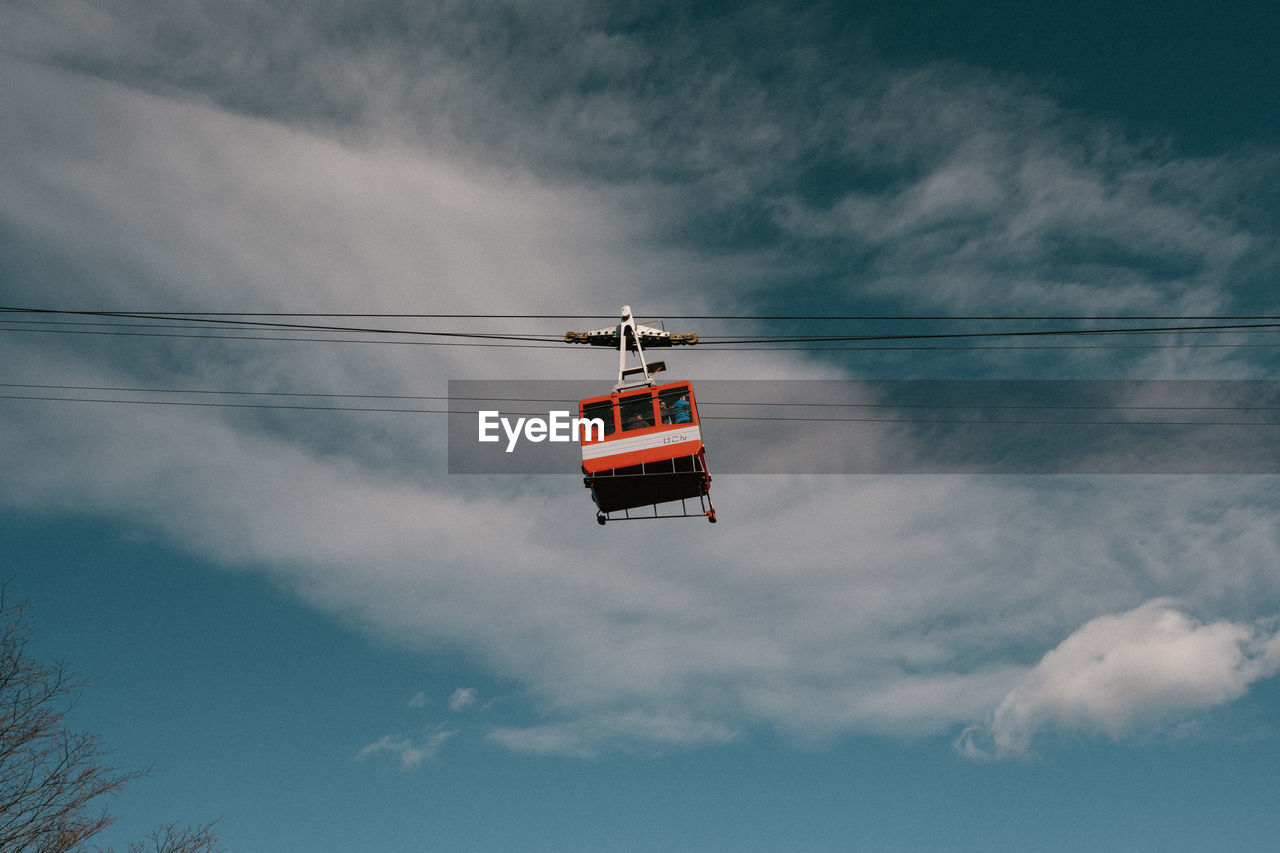 LOW ANGLE VIEW OF OVERHEAD CABLE CAR AGAINST CLOUDY SKY