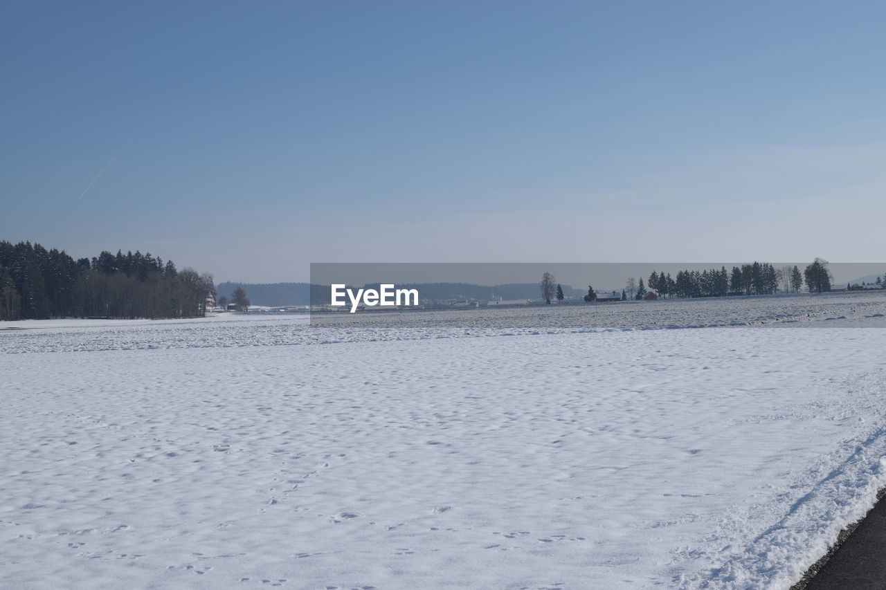 SCENIC VIEW OF FROZEN LAKE AGAINST SKY