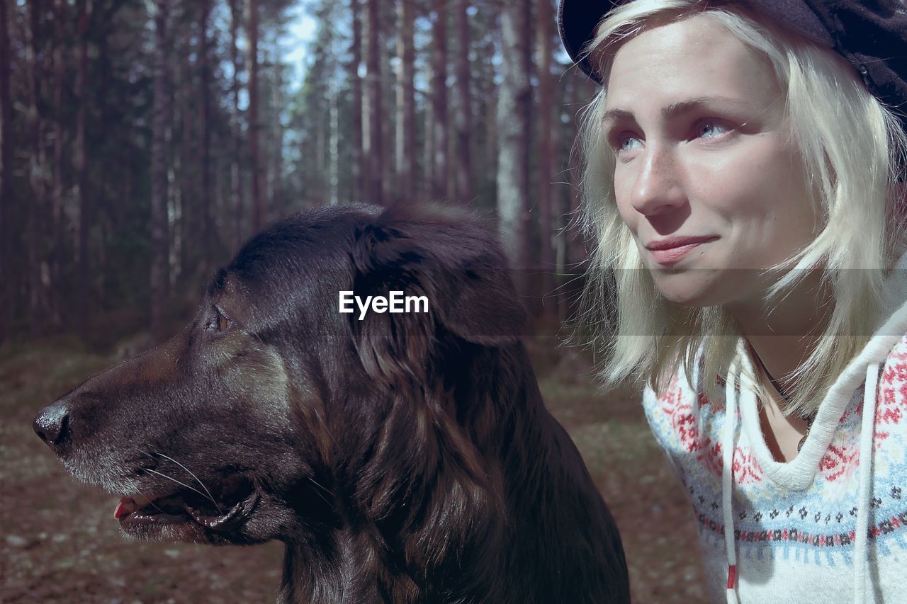 Close-up of woman with dog in forest