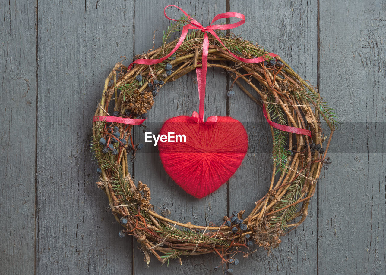 HIGH ANGLE VIEW OF RED DECORATION HANGING ON WOOD