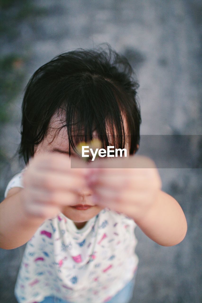 Close-up of girl holding tiny flowers