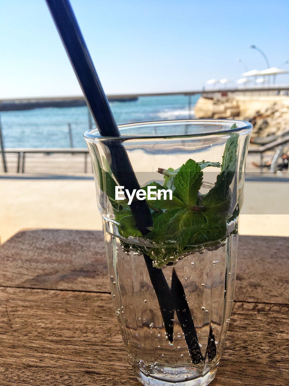 CLOSE-UP OF DRINK ON TABLE AT BEACH