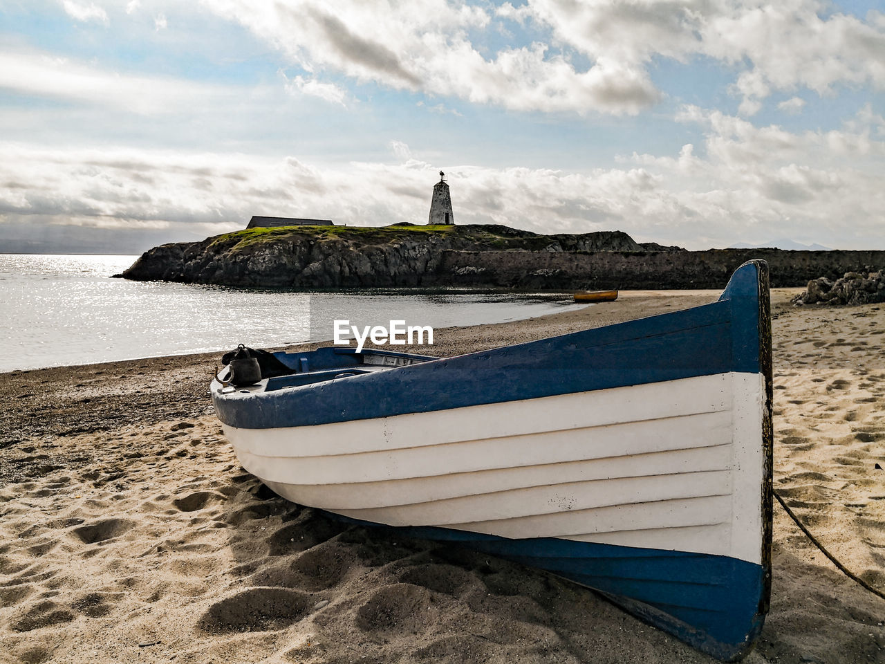 Ship moored on beach against sky