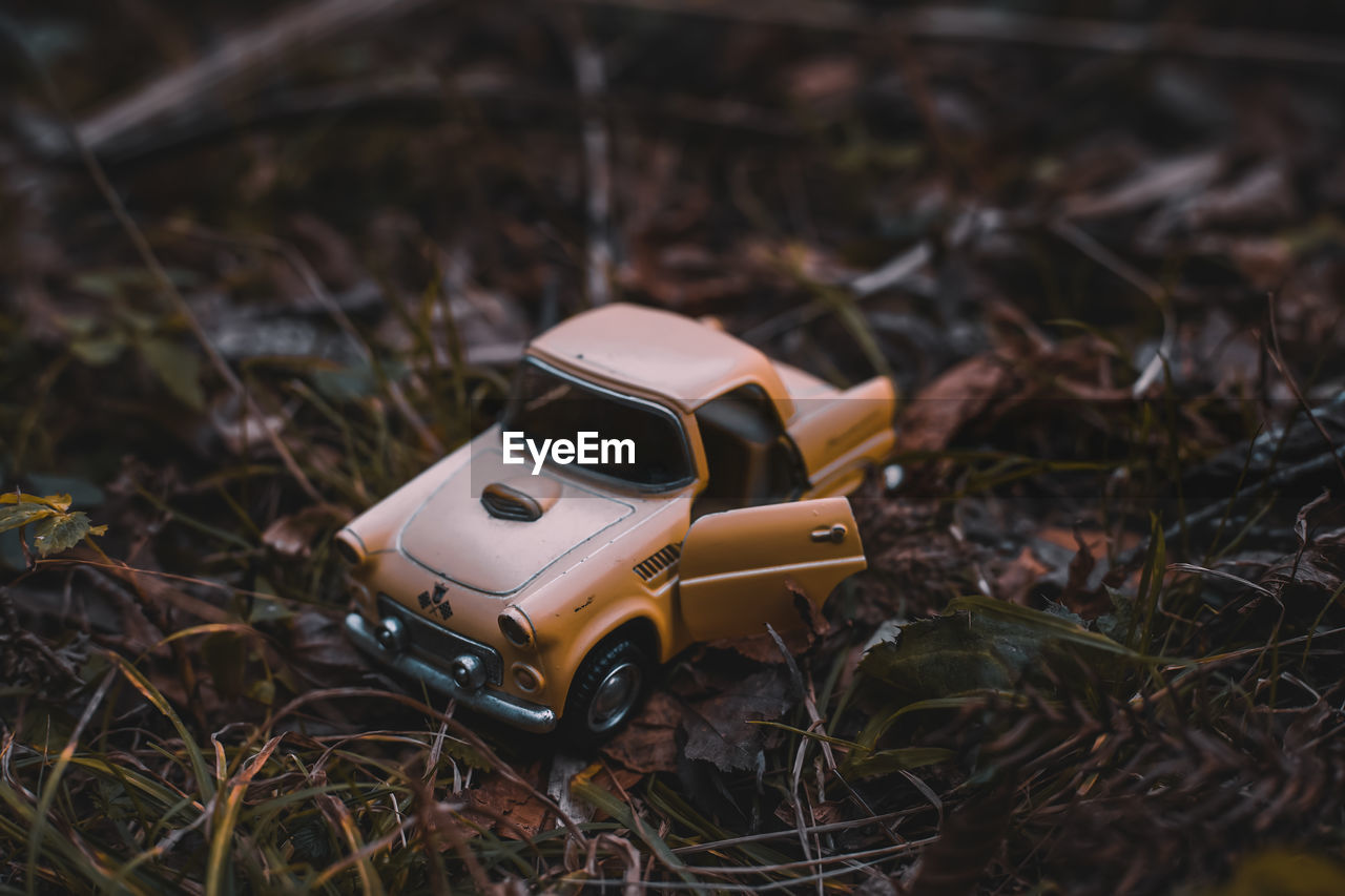 HIGH ANGLE VIEW OF TOY CAR ON LAND