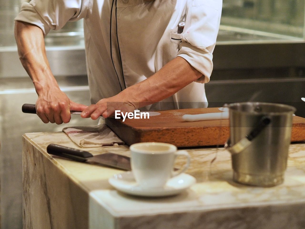 Midsection of chef preparing food at commercial kitchen