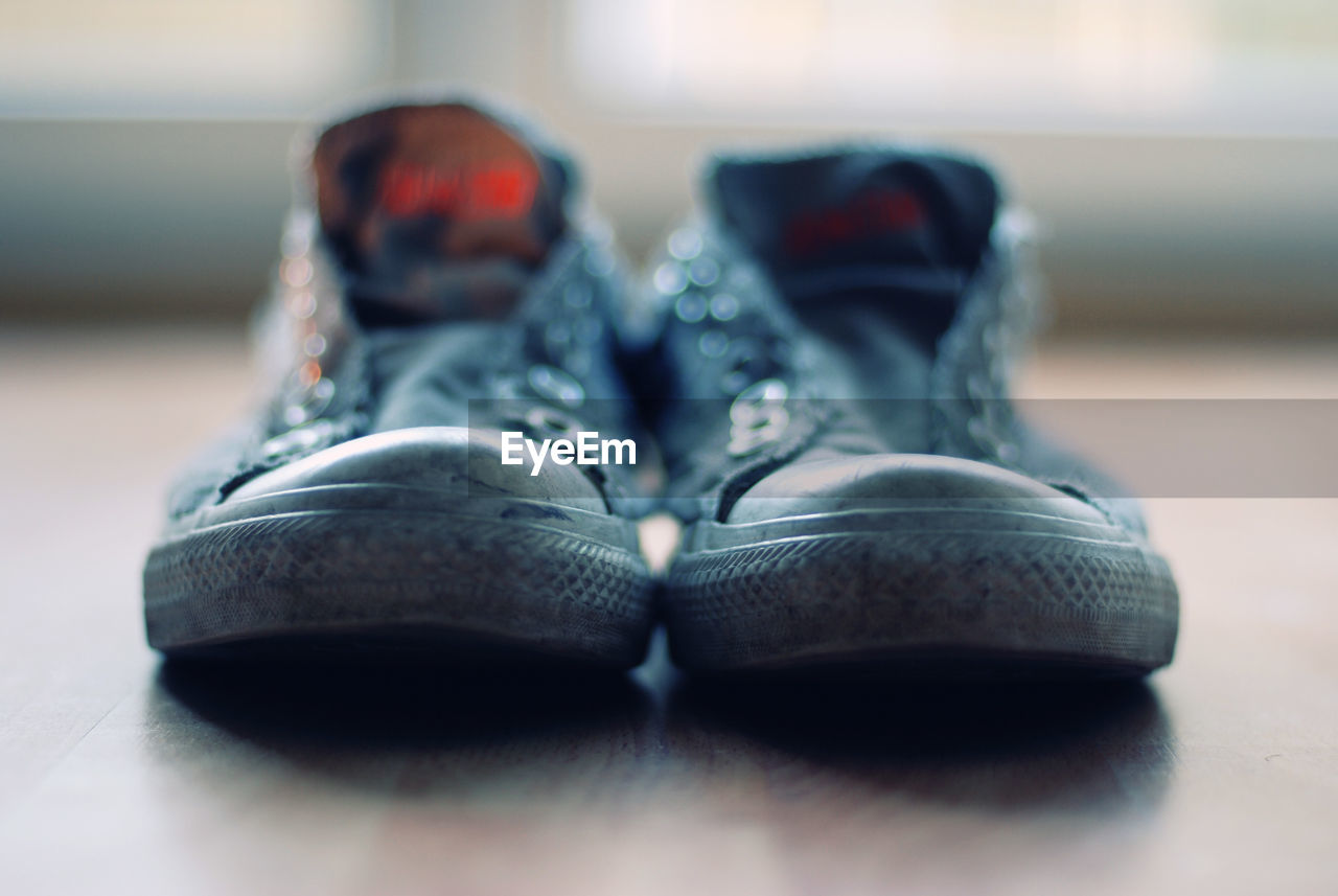 Close-up of shoes on hardwood floor at home