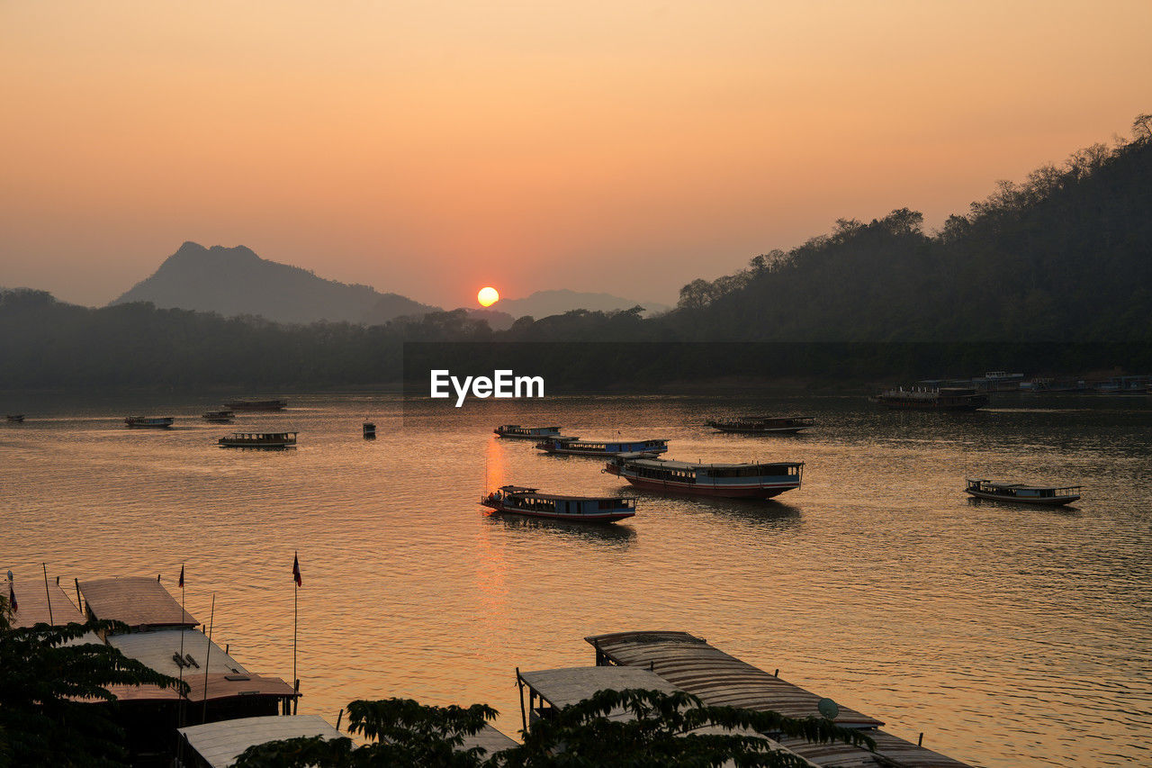 Wooden boats at the mekong river of luang prabang in laos southeast asia during the sunset time