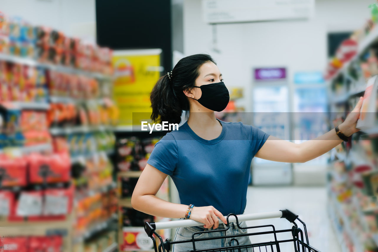 YOUNG WOMAN WITH BICYCLE ON STORE AT HOME