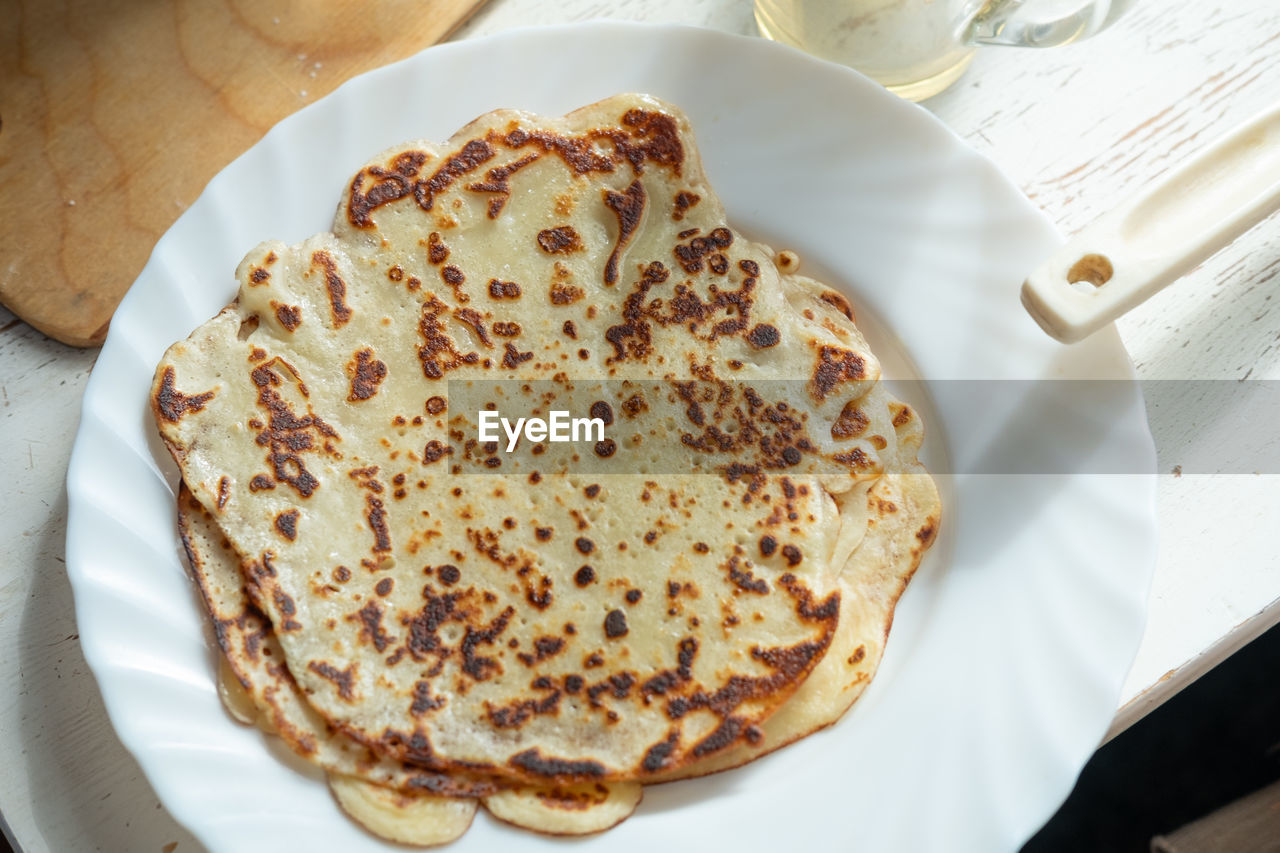 food and drink, food, dish, plate, freshness, meal, breakfast, high angle view, indoors, cuisine, no people, table, still life, sweet food, baked, naan, fast food, produce, close-up, bread, directly above, flatbread, dessert, serving size, paper, healthy eating, sweet, temptation