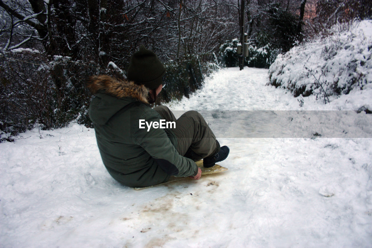 MAN SITTING ON SNOW