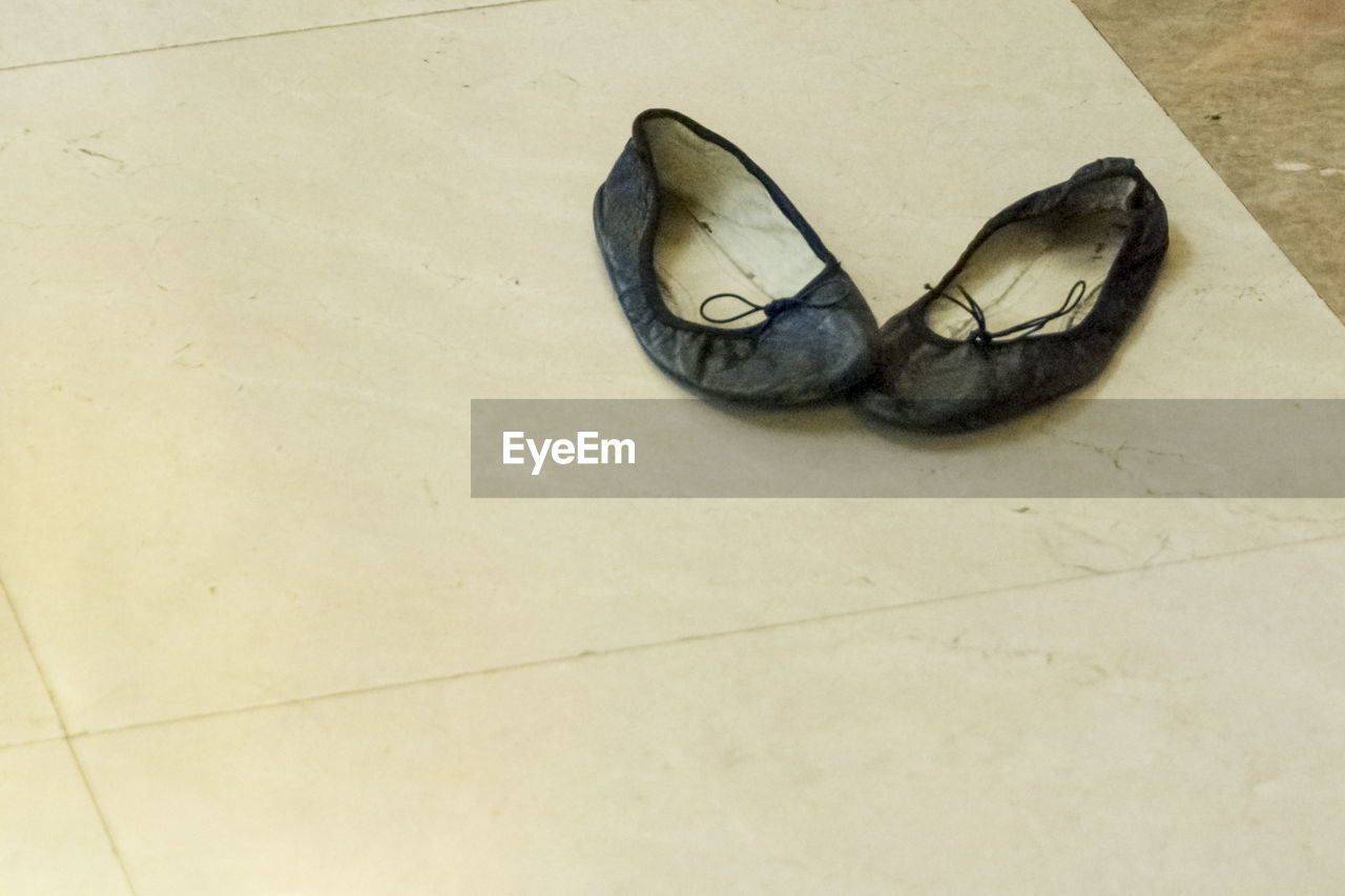 PAIR OF SHOES ON TILED FLOOR