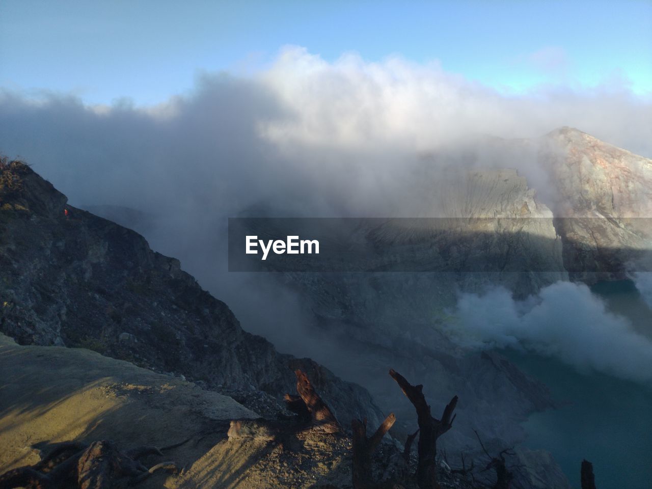 Smoke emitting from volcanic mountain against sky