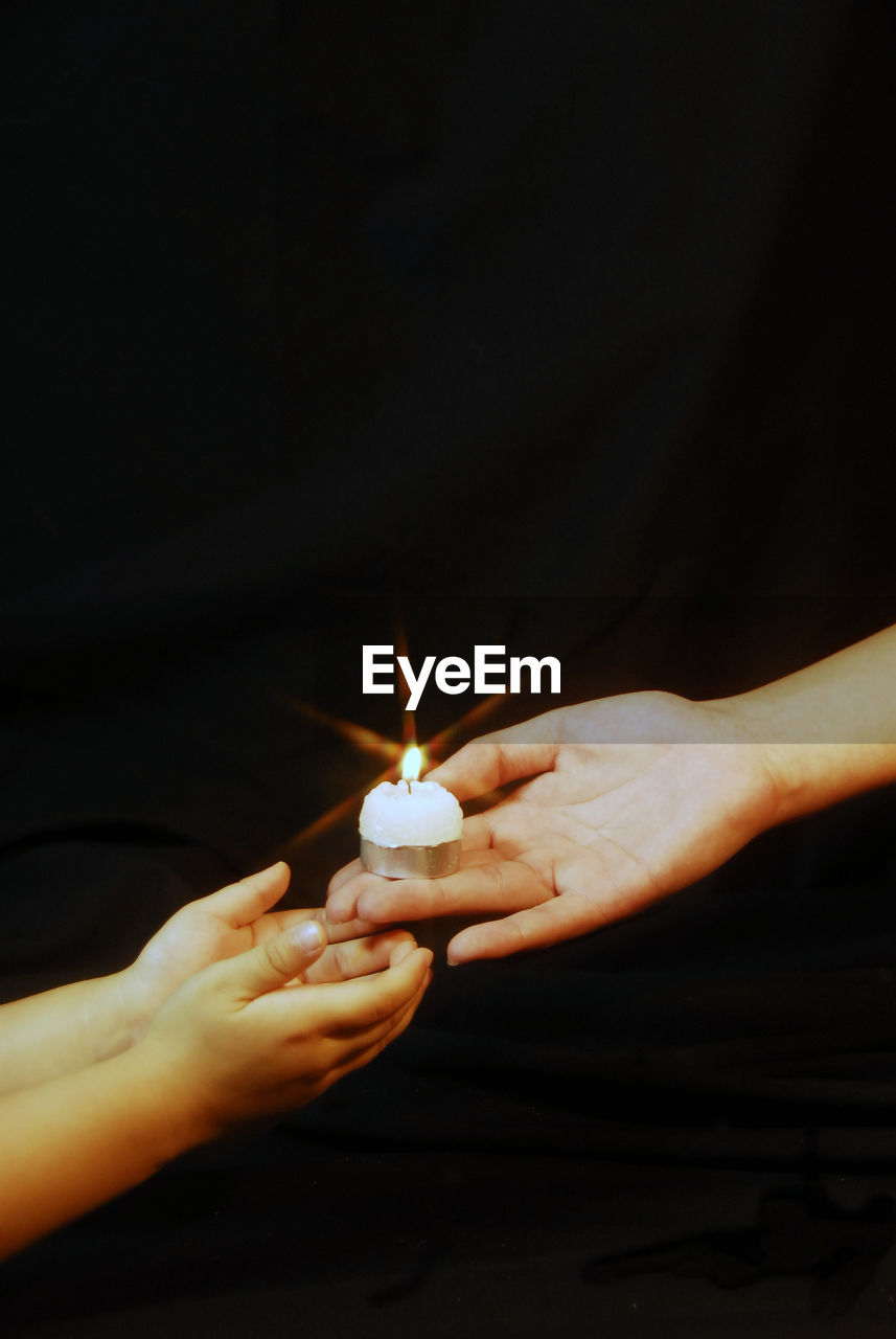 CLOSE-UP OF HAND HOLDING ILLUMINATED LIGHT