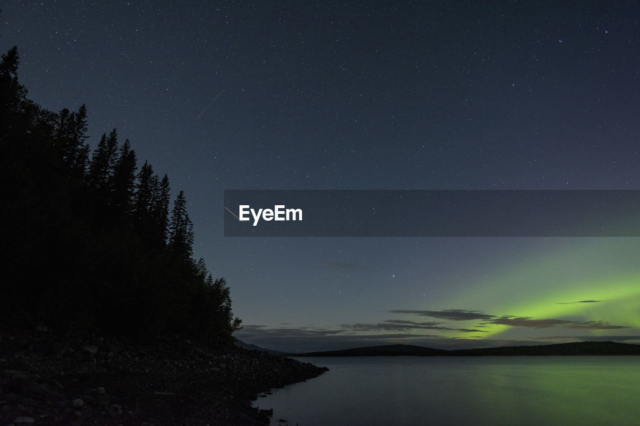 Scenic view of lake against sky at night