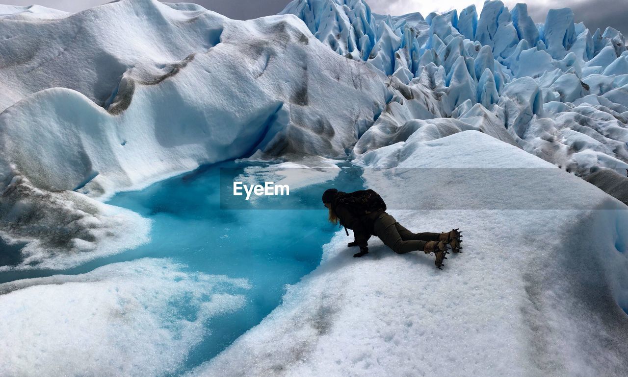 Woman lying on glacier