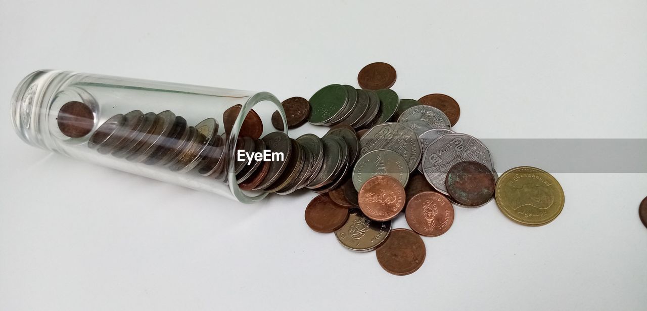 HIGH ANGLE VIEW OF COINS ON WHITE BACKGROUND