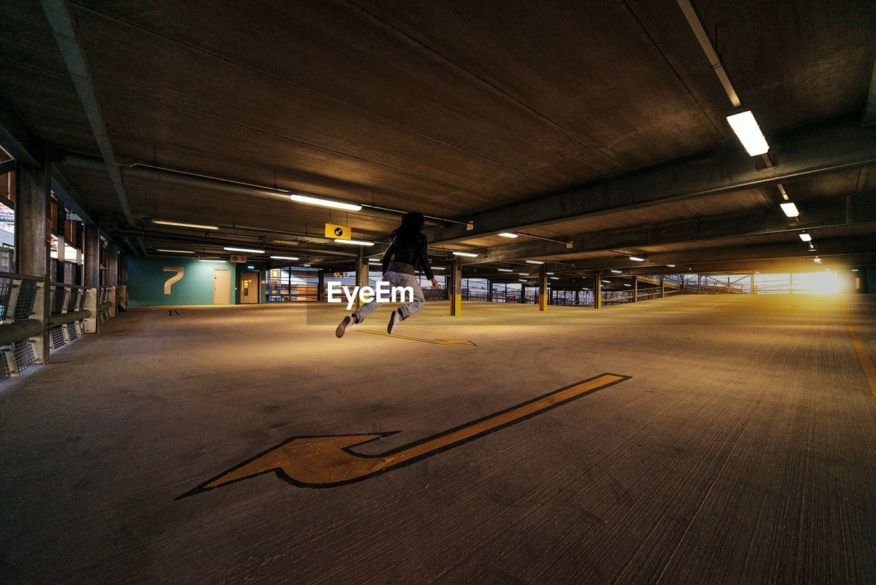 Rear view of person levitating in parking lot