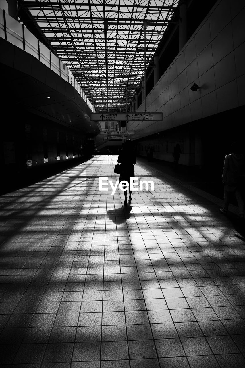 SILHOUETTE PEOPLE WALKING IN CORRIDOR OF BUILDING