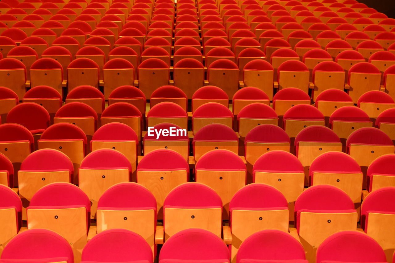 Close-up of red seats in a theatre.