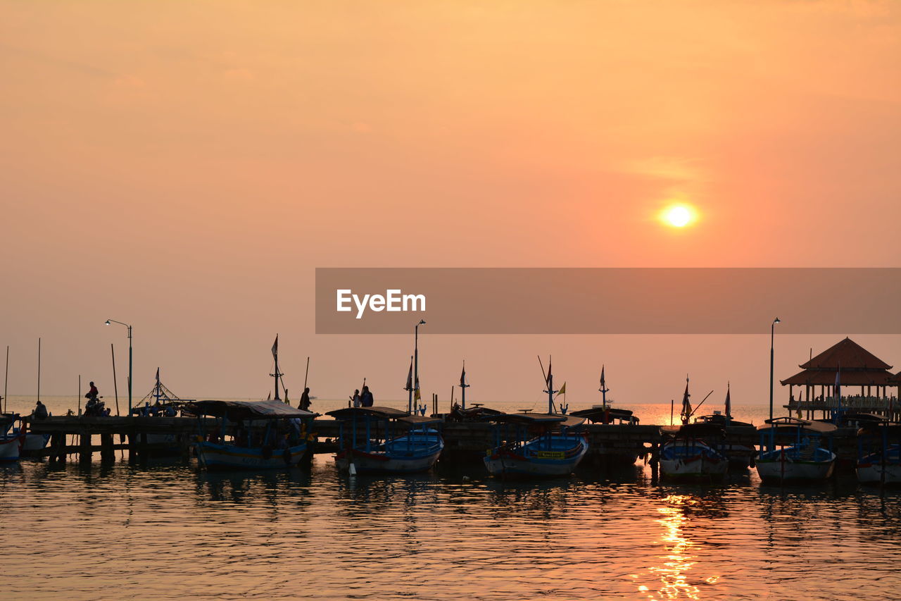 SILHOUETTE BOATS IN MARINA AT SUNSET